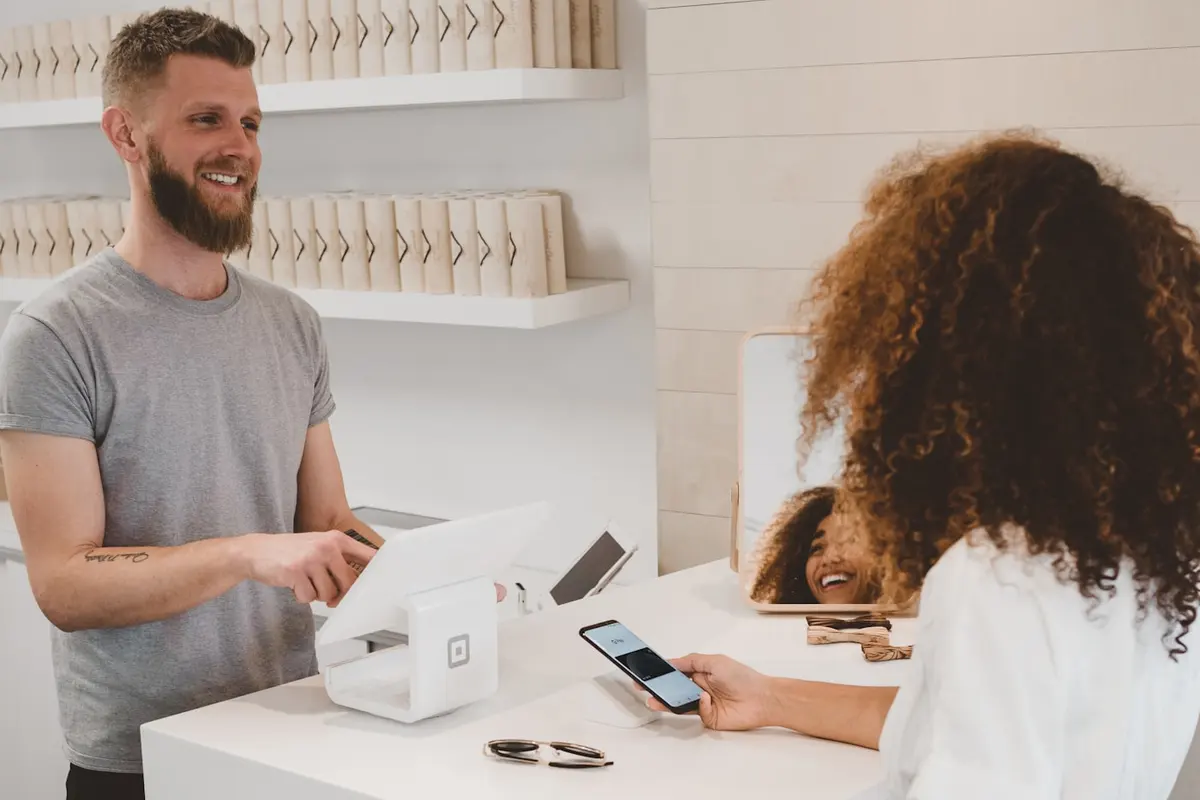Business owner behind a shop counter taking a card payment
